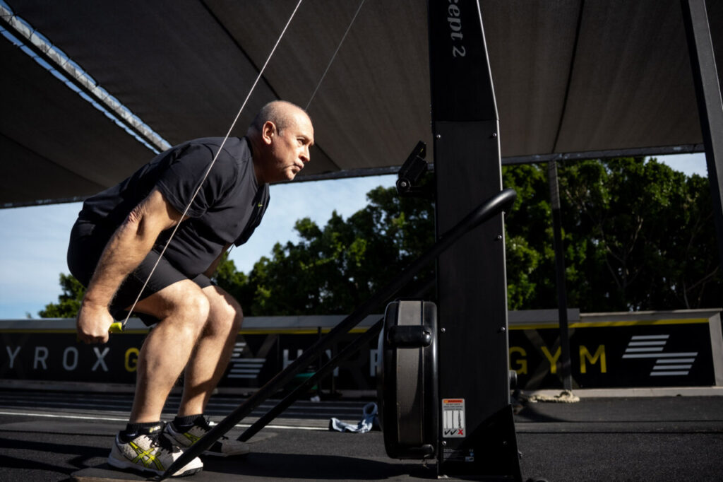 Hombre mayor entrenando fuerza en un gimnasio al aire libre
