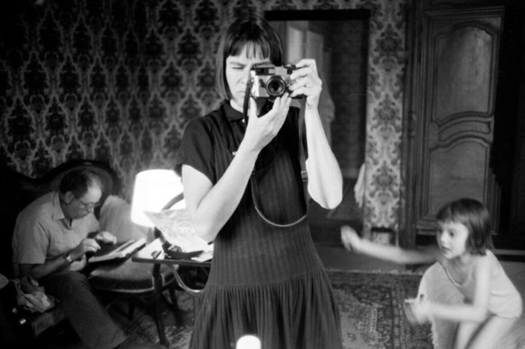 Mujer tomando una fotografía con una cámara en un ambiente familiar.