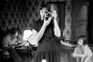 Mujer tomando una fotografía con una cámara en un ambiente familiar.