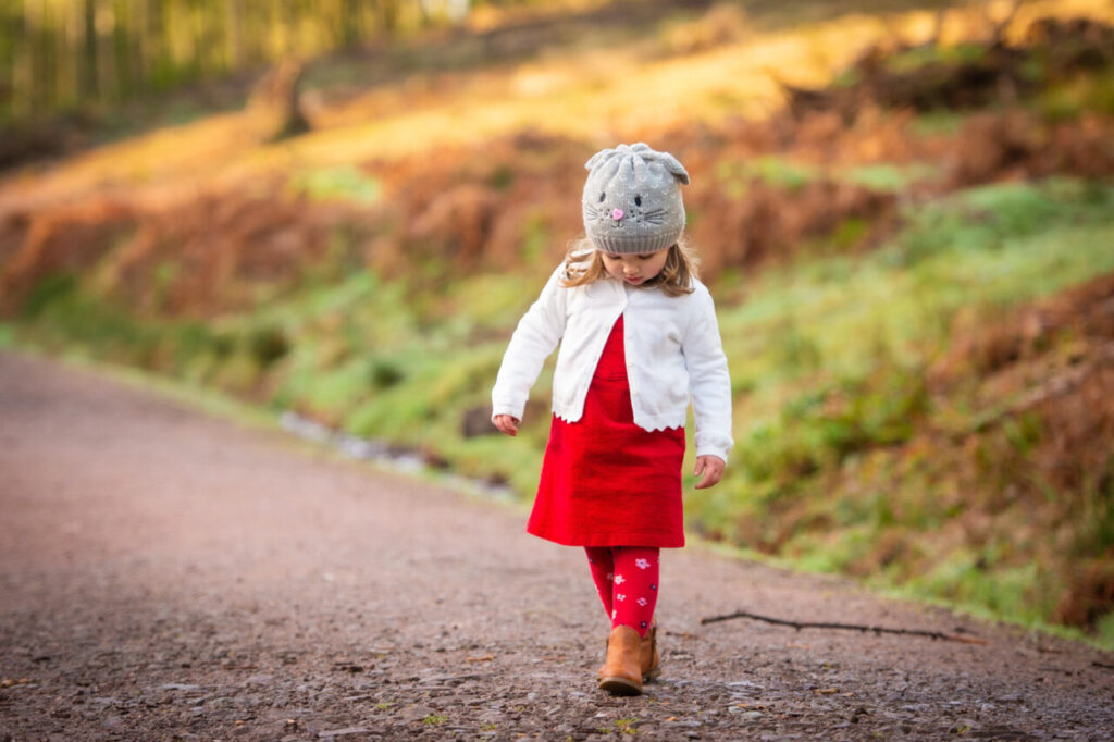 Niña pequeña caminando por un sendero con ropa colorida