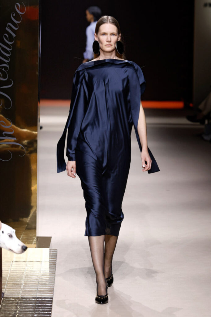 Modelo desfilando con un vestido azul oscuro en la pasarela de MBFWM.