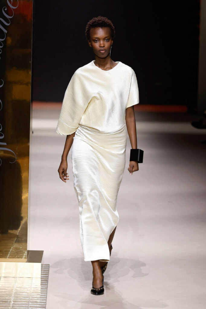 Modelo desfilando con vestido blanco en la pasarela de MBFWM