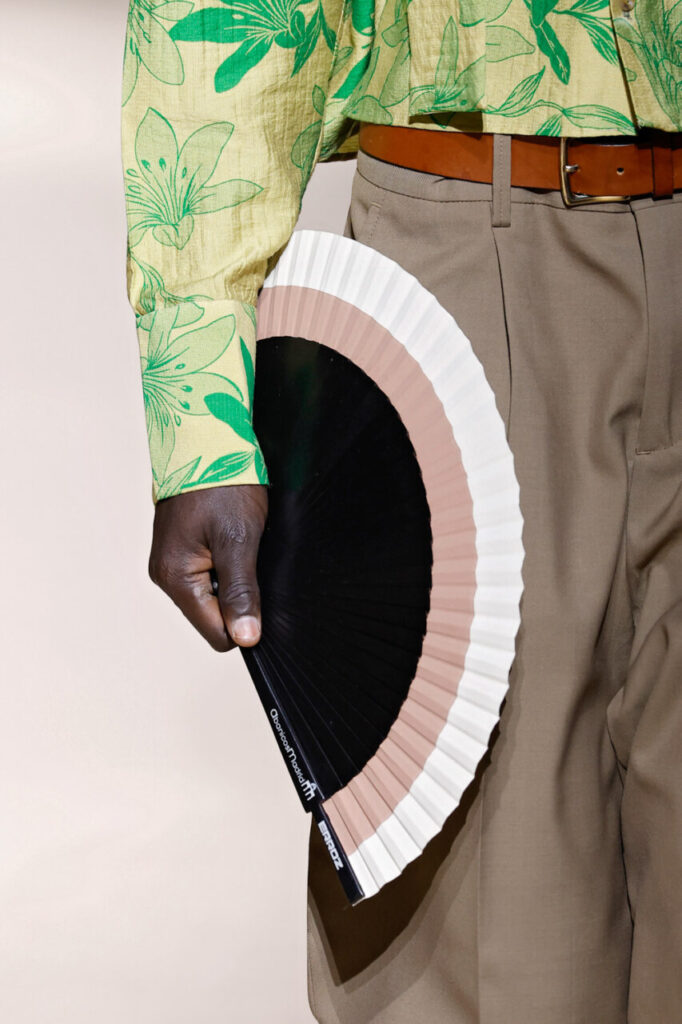 Modelo sosteniendo un abanico en un desfile de moda