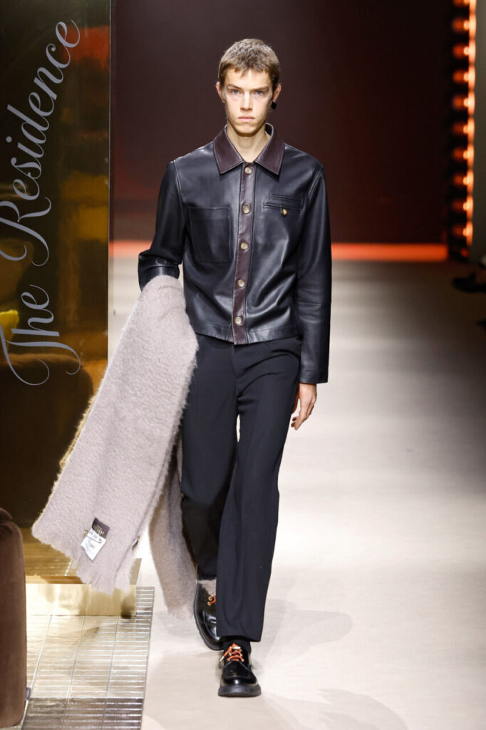 Modelo masculino en pasarela con abrigo y camisa de cuero en MBFWM