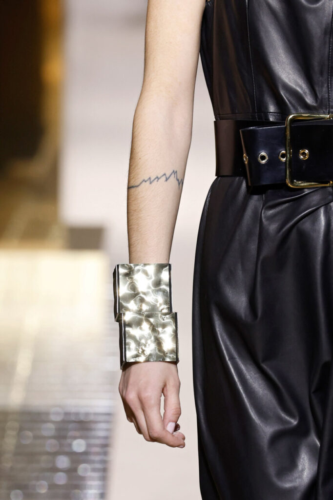 Detalle de un look de Pablo Erroz con un brazalete metálico y un vestido negro.