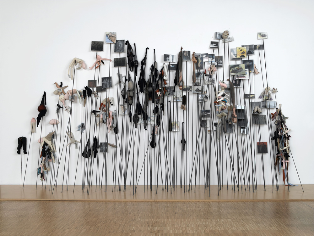 Boltanski Messager 4 Instalación artística con figuras y fotografías en varillas metálicas