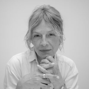 Retrato en blanco y negro de una mujer con cabello corto y manos entrelazadas