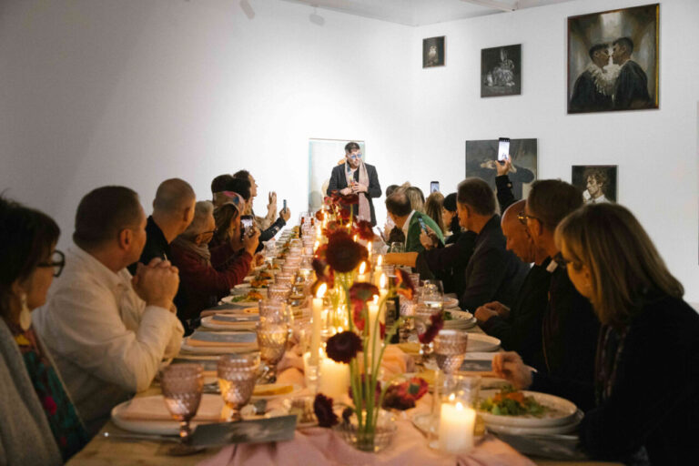 Cena en un ambiente artístico con invitados disfrutando de la comida