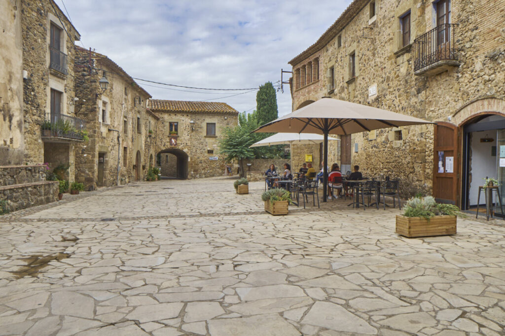 Peratallada: el pueblo medieval que detiene el tiempo en el Baix Empordà 11 Plaza con casas de piedra y mesas al aire libre en el Pirineo Catalán