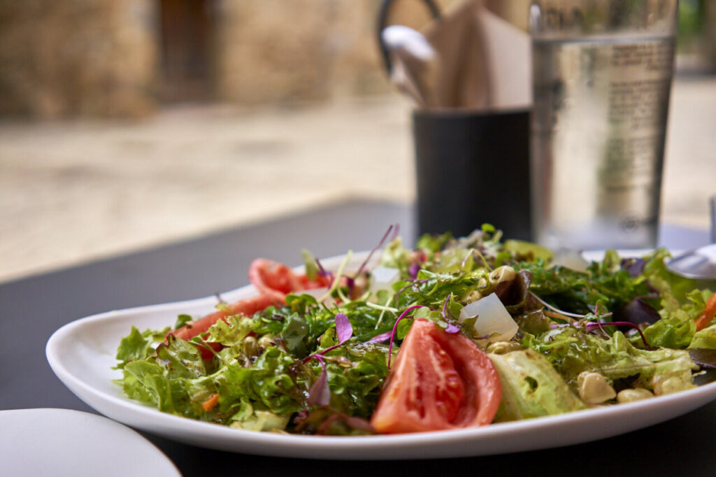 Ensalada fresca con lechuga, tomate y aderezo en un plato blanco