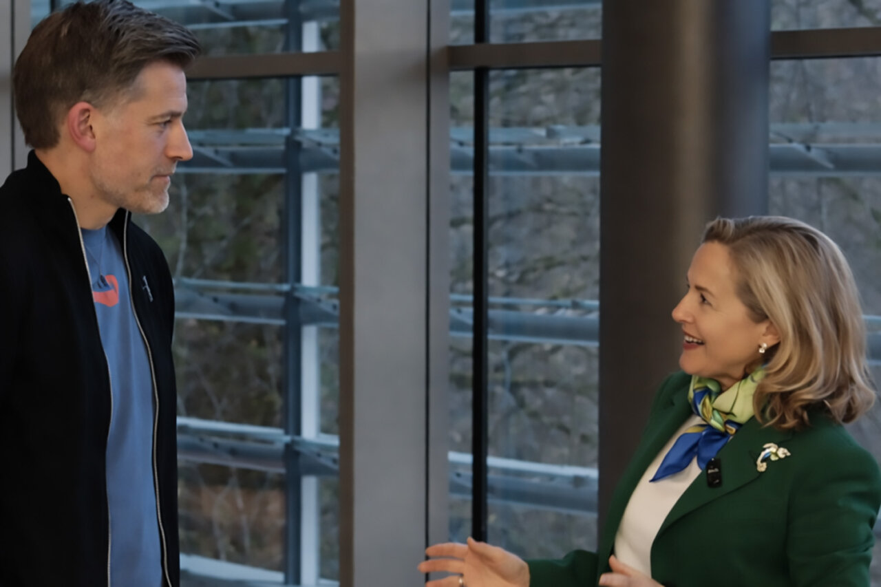 Nadia Calviño interactuando mientras se prueba un traje moderno.