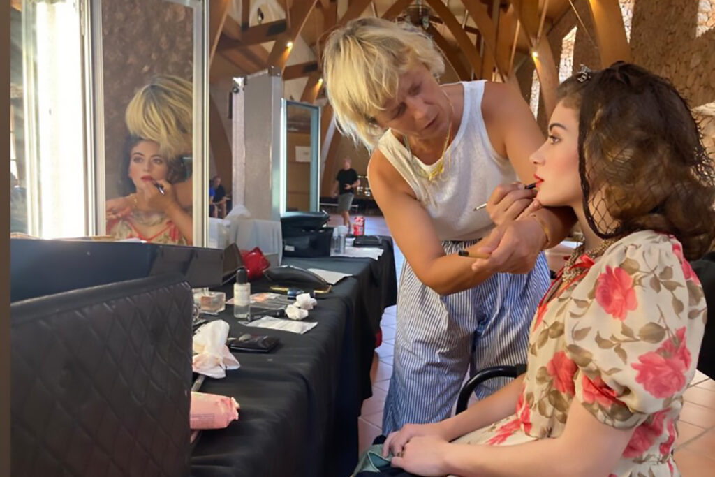 Artista maquillando a modelo en un entorno creativo