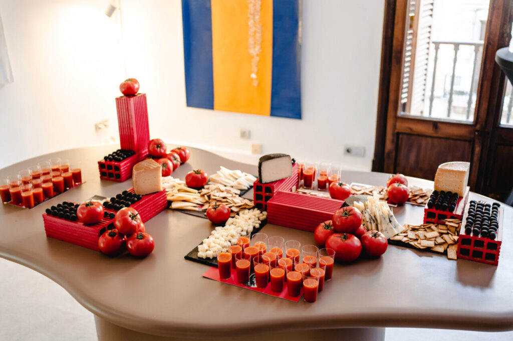 Mesa decorada con tomates, quesos y bebidas en La Bibi Gallery