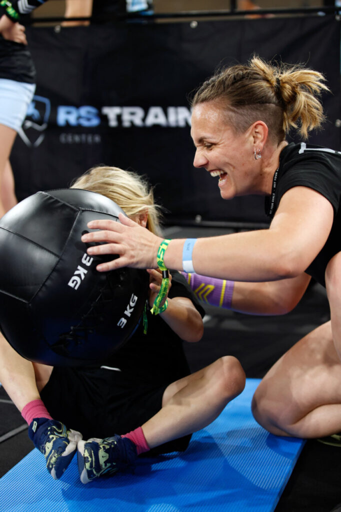 Entrenadora animando a un niño en una competición de fitness funcional