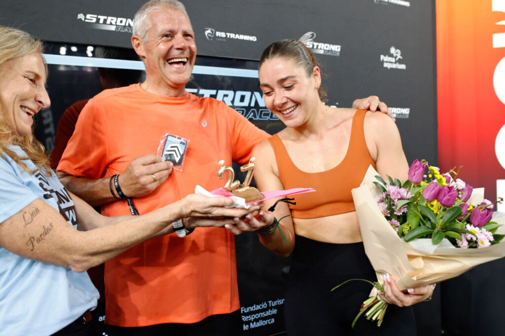 Atletas celebrando en la Strong Race 2026 con trofeos y flores