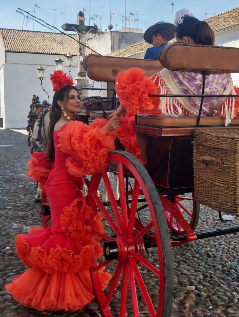 Mujer en traje de flamenco rojo interactuando con un carruaje