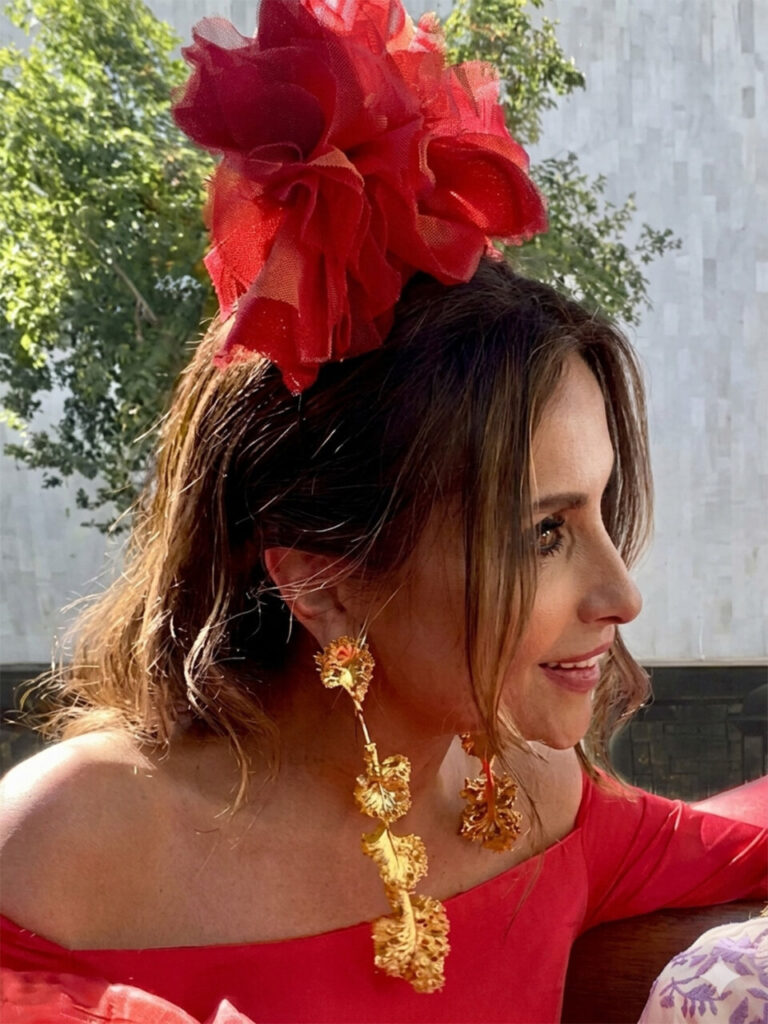 Mujer con peinado y accesorios rojos en un entorno natural