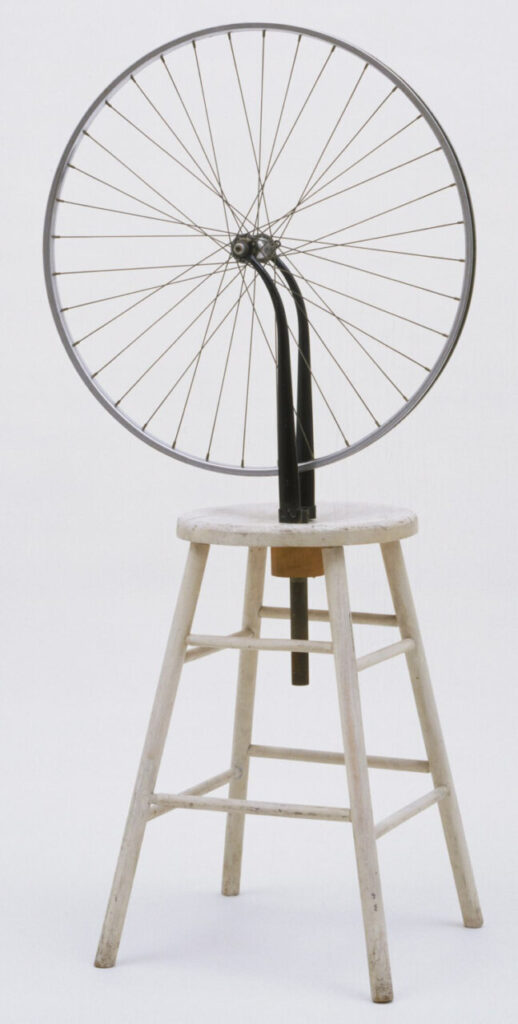 The Essential Gesture 3 Rueda de bicicleta montada sobre un taburete blanco