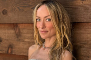Olivia Wilde con cabello largo y rubio en un fondo de madera