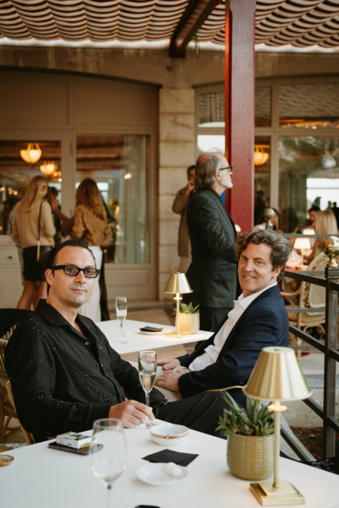 Dos hombres sentados en una mesa durante la inauguración de Es Balcó en Mallorca
