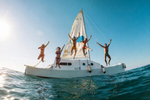 Grupo de amigos saltando desde un barco en Ibiza