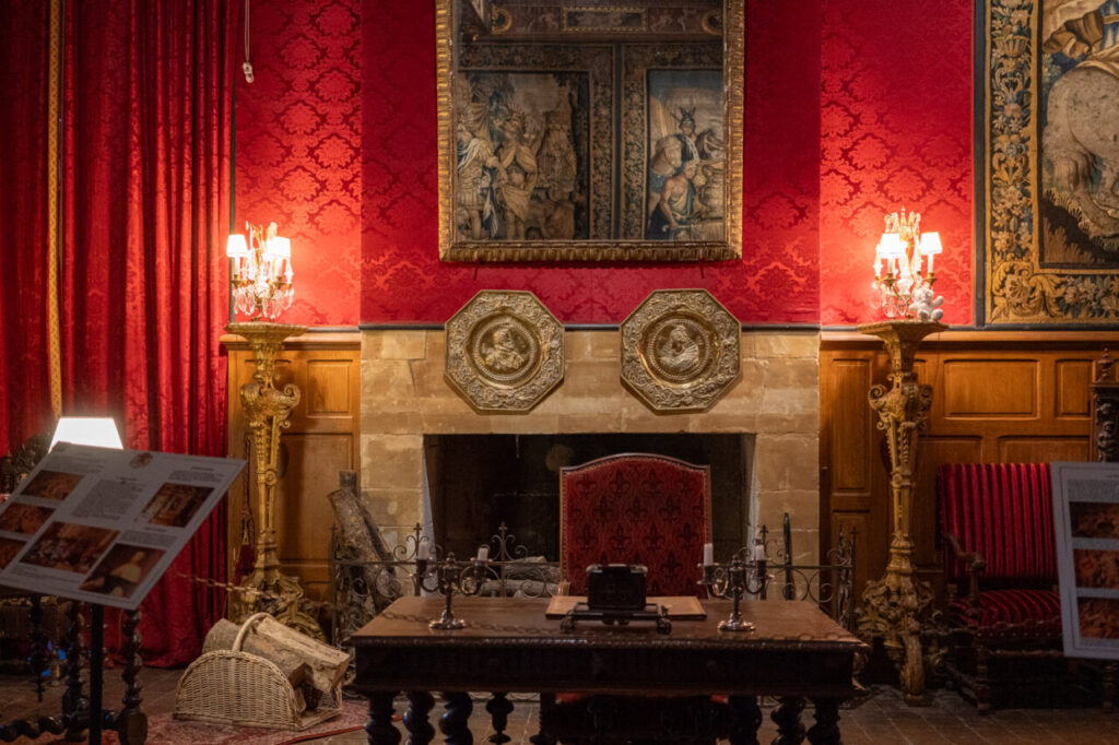 Salón del castillo de Brissac con decoración roja y muebles antiguos
