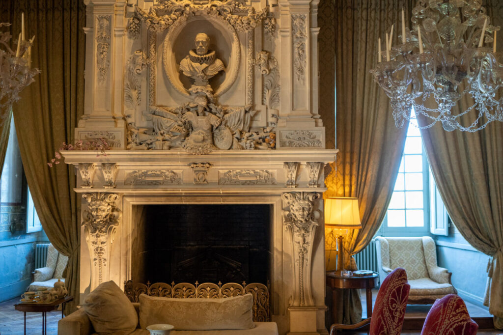 Salón del castillo de Brissac con chimenea decorada y muebles elegantes