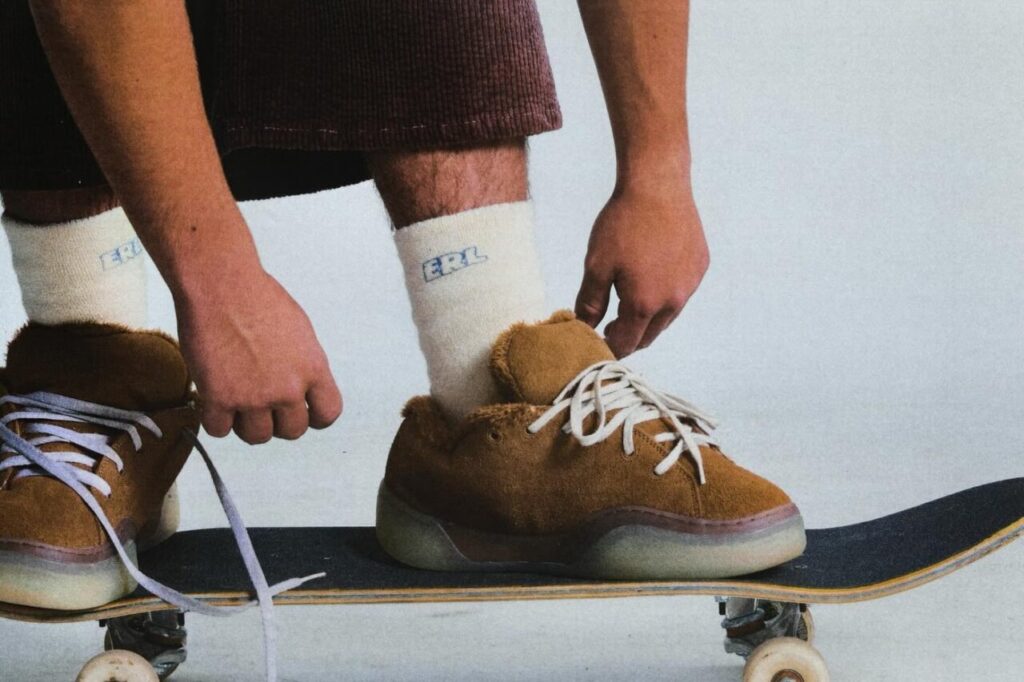 Persona ajustando zapatillas ERL sobre una patineta