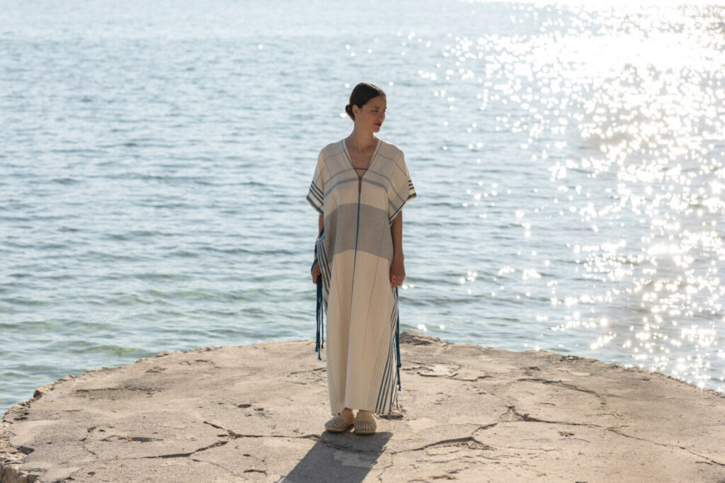 Modelo luciendo vestido de algodón junto al mar en Mallorca