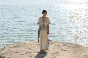 Modelo luciendo vestido de algodón junto al mar en Mallorca