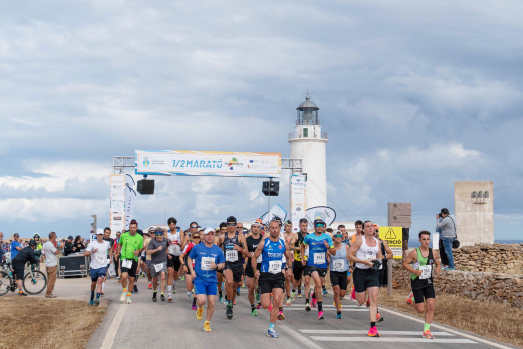 La Media Maratón de Formentera pone a prueba el cuerpo y regala el Mediterráneo a cambio 5 Corredores en la salida de la media maratón junto a un faro