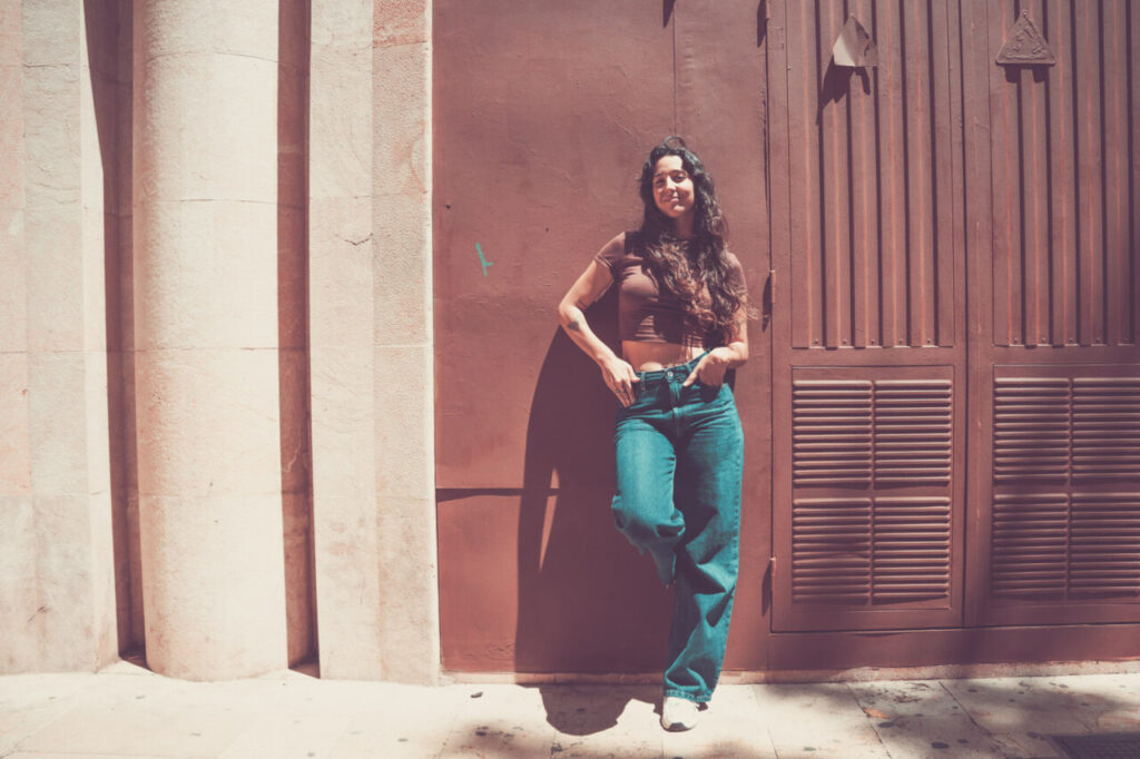 Mujer posando con jeans y top en un entorno urbano