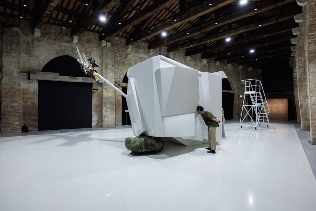 Instalación artística en la Bienal de Venecia con visitantes observando