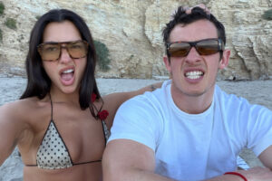 Dua Lipa y Callum Turner en la playa, haciendo caras divertidas