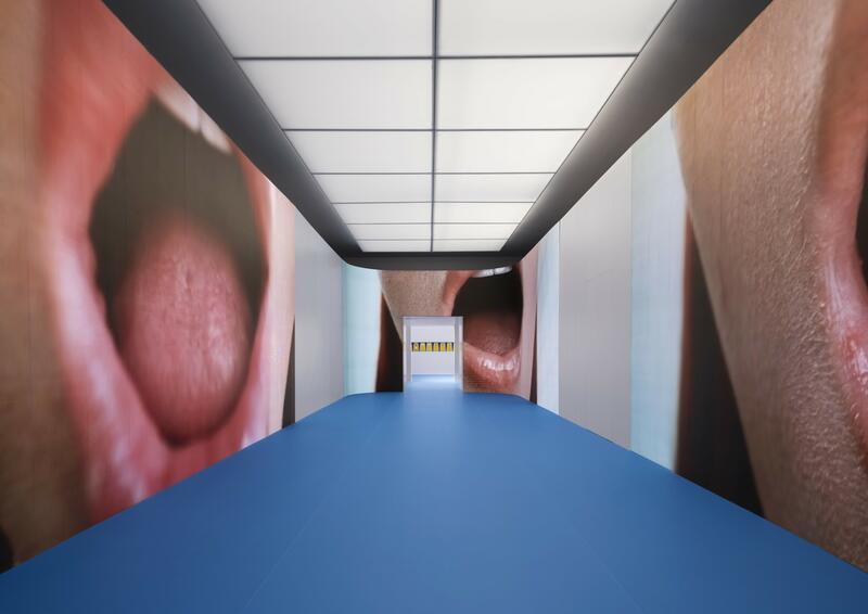 Instalación artística en la Bienal de Venecia con imágenes de bocas y un pasillo azul