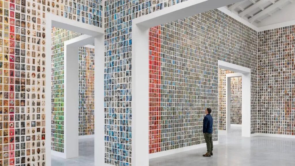 Instalación artística en la Bienal de Venecia con múltiples imágenes en las paredes