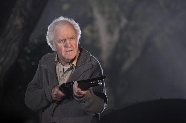 James Handy interpretando un papel con un rifle en la mano