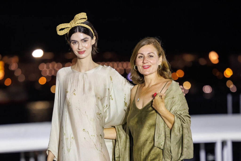 Pasarela Adlib Ibiza celebra su 55 aniversario reivindicando la libertad, la artesanía y el alma mediterránea de la isla 6 Modelo y asistente en la Pasarela Adlib Ibiza con fondo iluminado