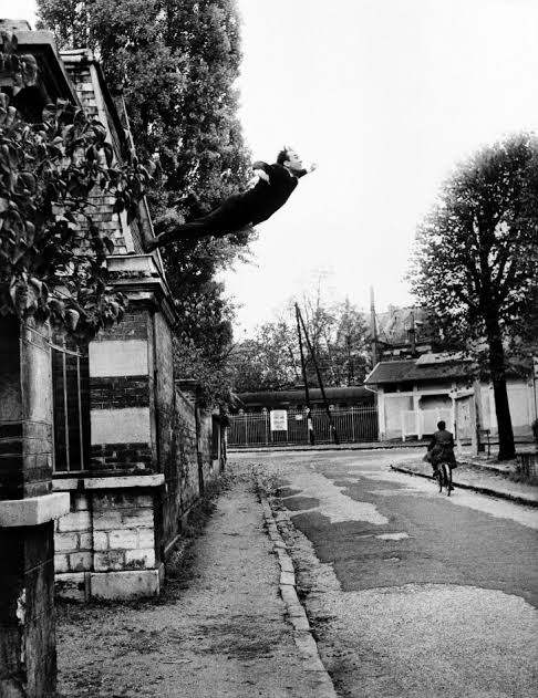 Un artista realizando un salto desde un edificio en blanco y negro
