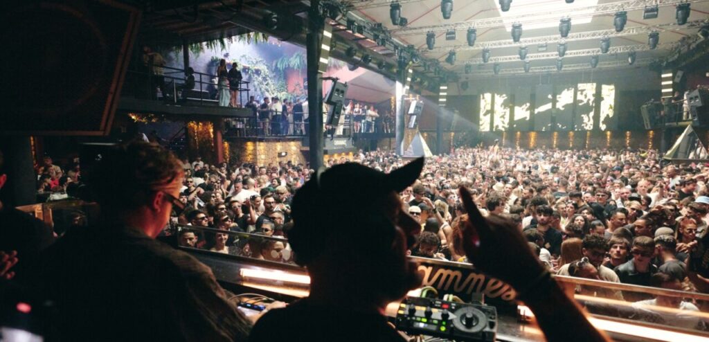 Vista del club Amnesia en Ibiza con DJ y multitud de asistentes disfrutando