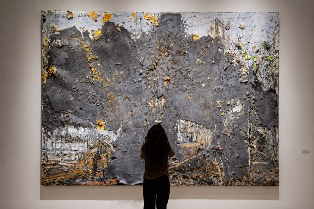 Paisaje Kiefer 2 Persona observando una obra de arte abstracto en una galería