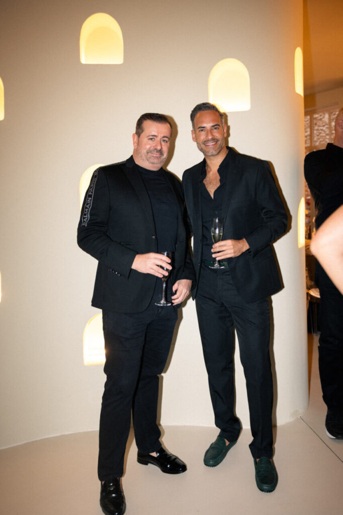 La inauguración de The Curated House: Una experiencia estética única en Ses Salines 6 Dos hombres en trajes oscuros sosteniendo copas en un evento de moda.