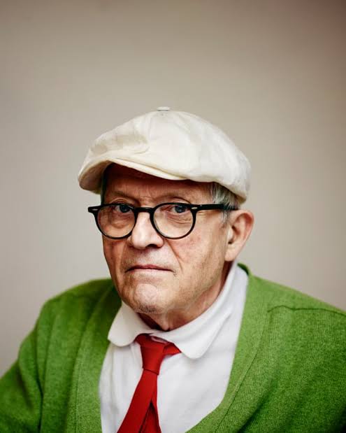 Retrato de David Hockney con gorra y suéter verde