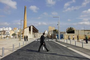 Fotografía de un hombre caminando en una calle de Palma con edificios al fondo