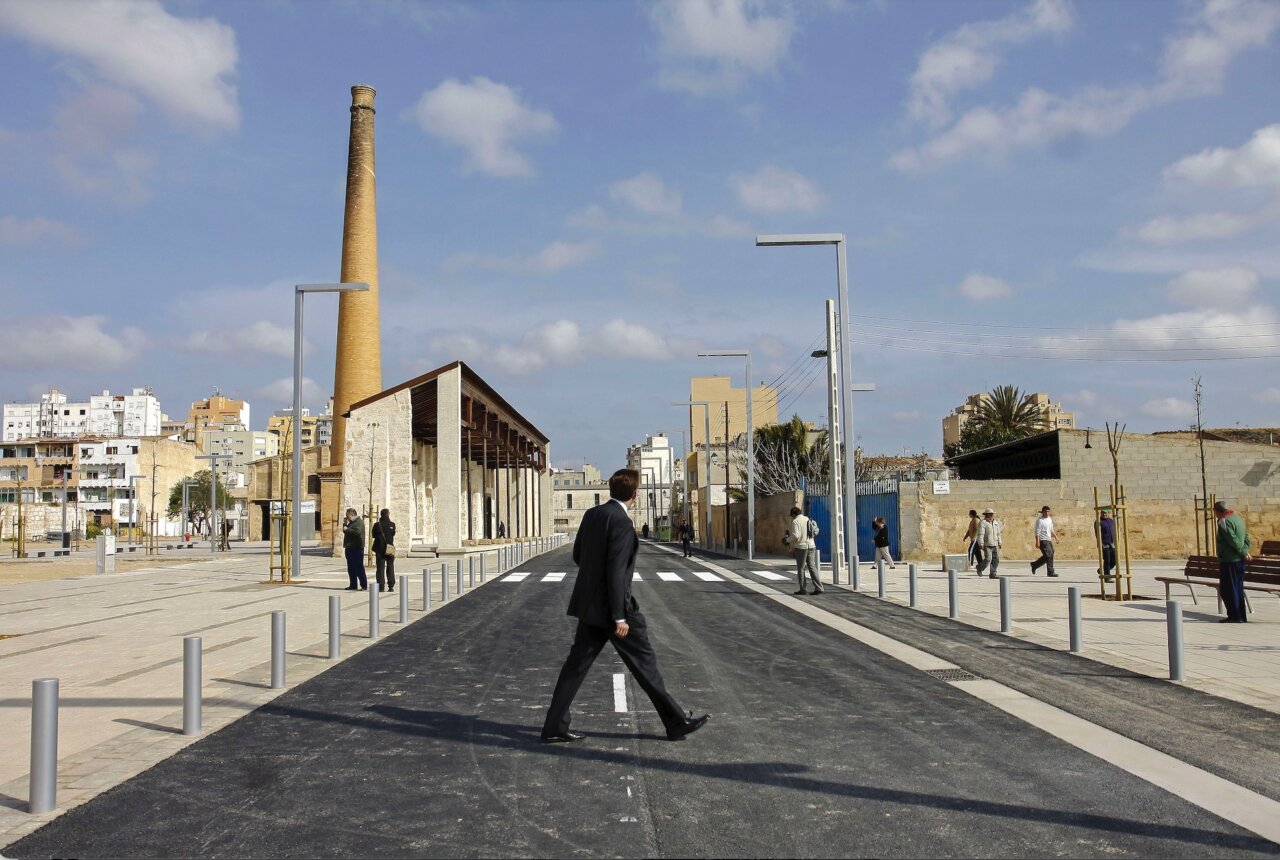 Fotografía de un hombre caminando en una calle de Palma con edificios al fondo