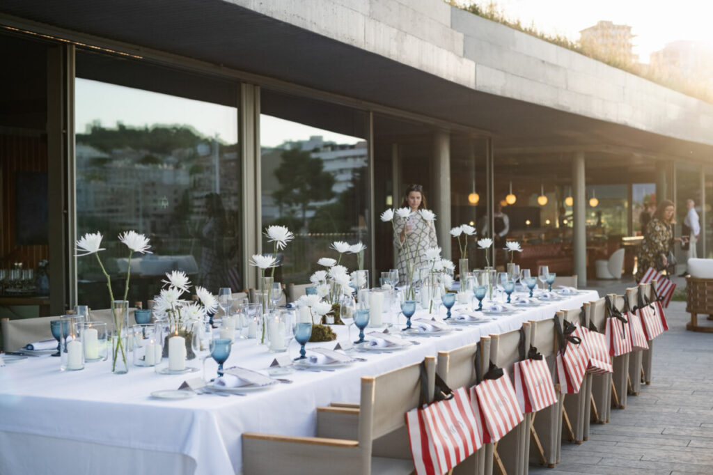 Cuando la moda se sentó frente al mar 24 Mesa elegantemente decorada con flores y velas en evento de inauguración.