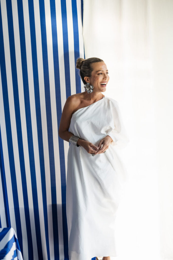 Cuando la moda se sentó frente al mar 17 Mujer sonriente con vestido blanco en un evento elegante