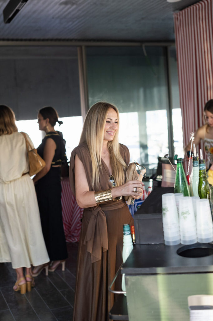 Cuando la moda se sentó frente al mar 16 Mujer sonriente en evento de inauguración con decoración elegante