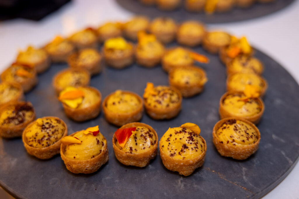 Deliciosos aperitivos decorados con flores en un evento de diseño