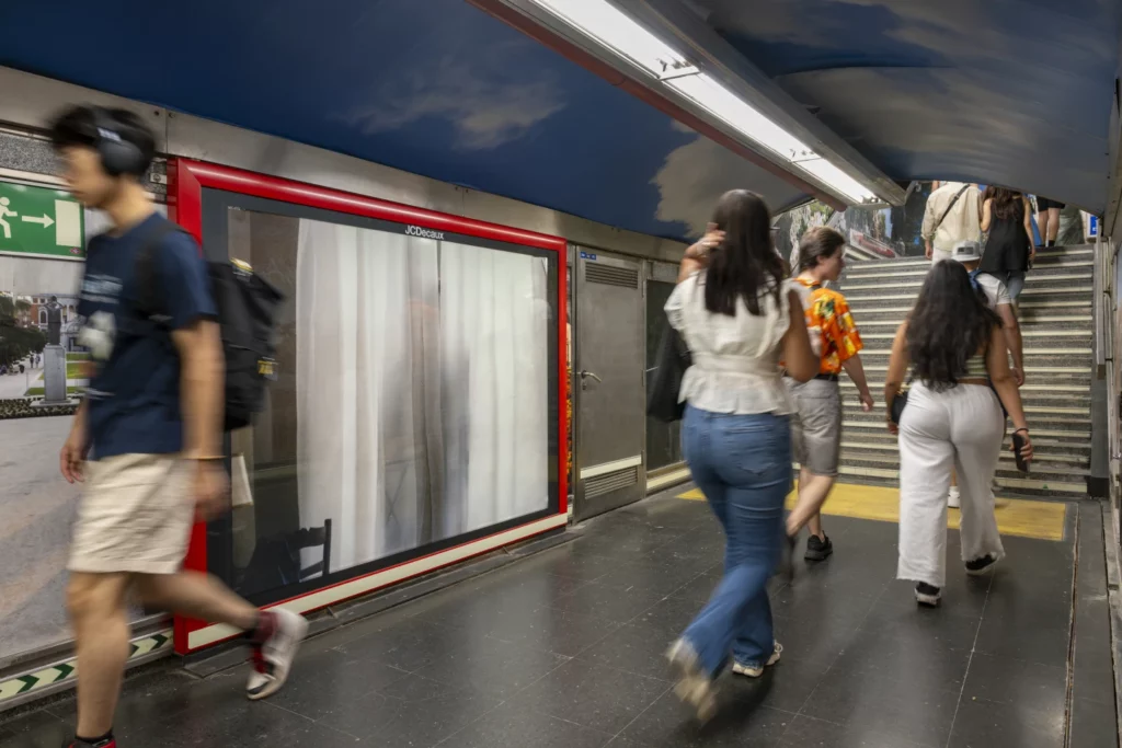 Dulce venganza 1 Personas caminando en una estación de metro con arte contemporáneo